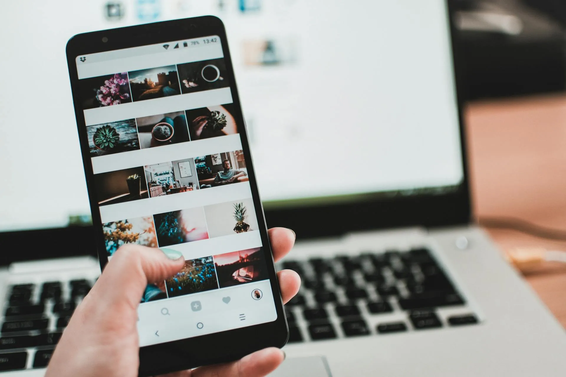 Imagen de ordenador y un movil en primer plano mostrando una galeria de imagenes