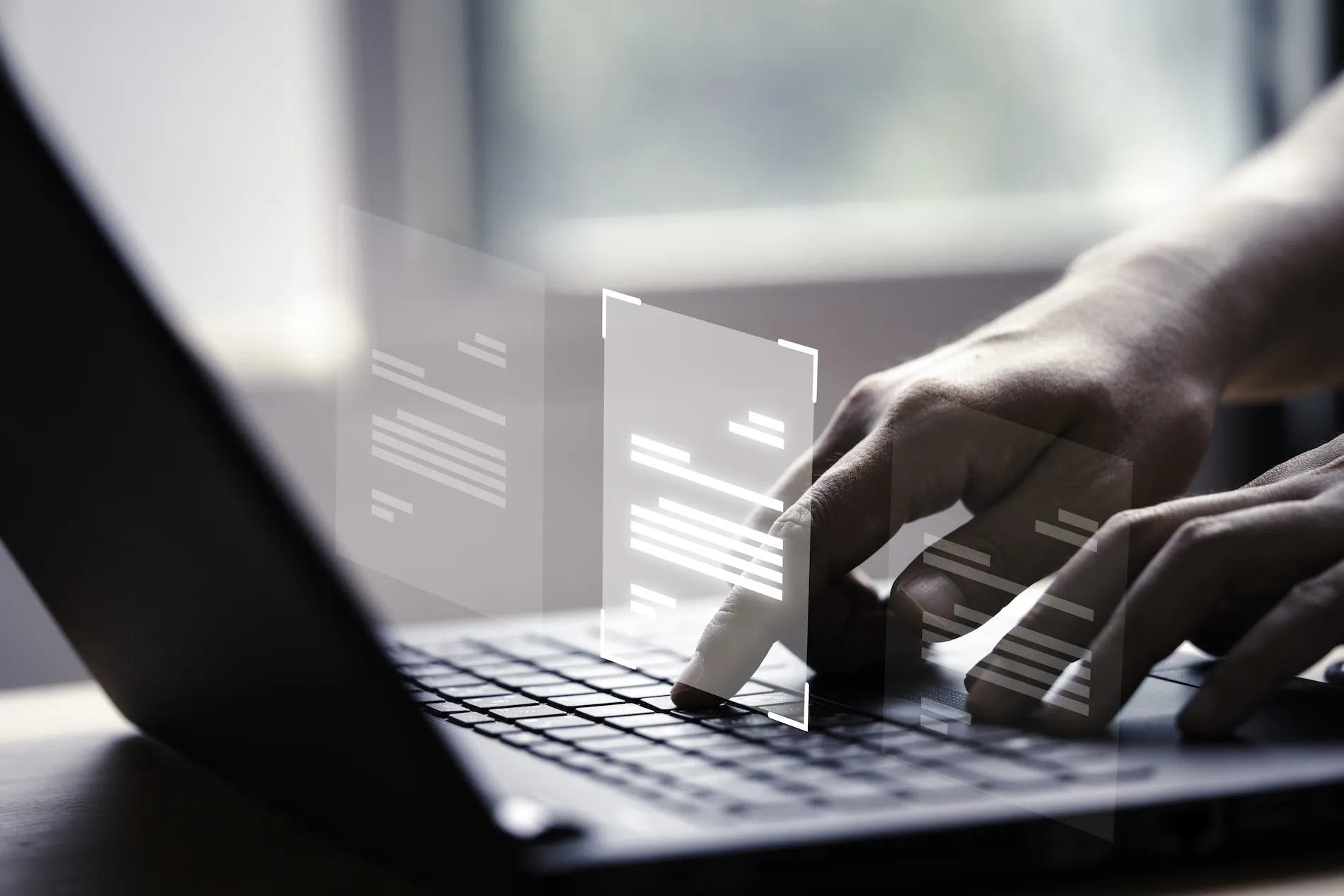 Manos escribiendo en portátil con documentos digitales virtuales flotantes